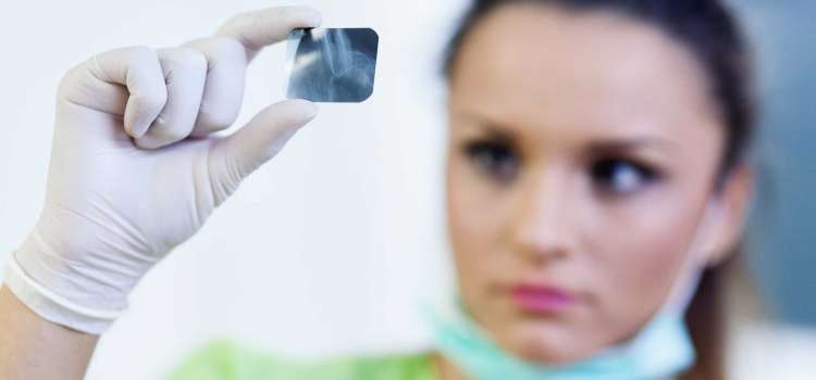 Portrait of a woman dentist looking at a dental radiography